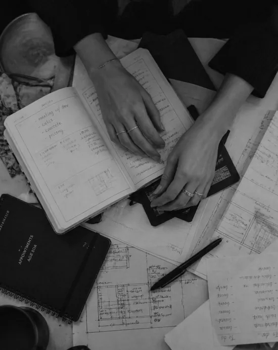 Mãos sobre cadernos e plantas de projeto